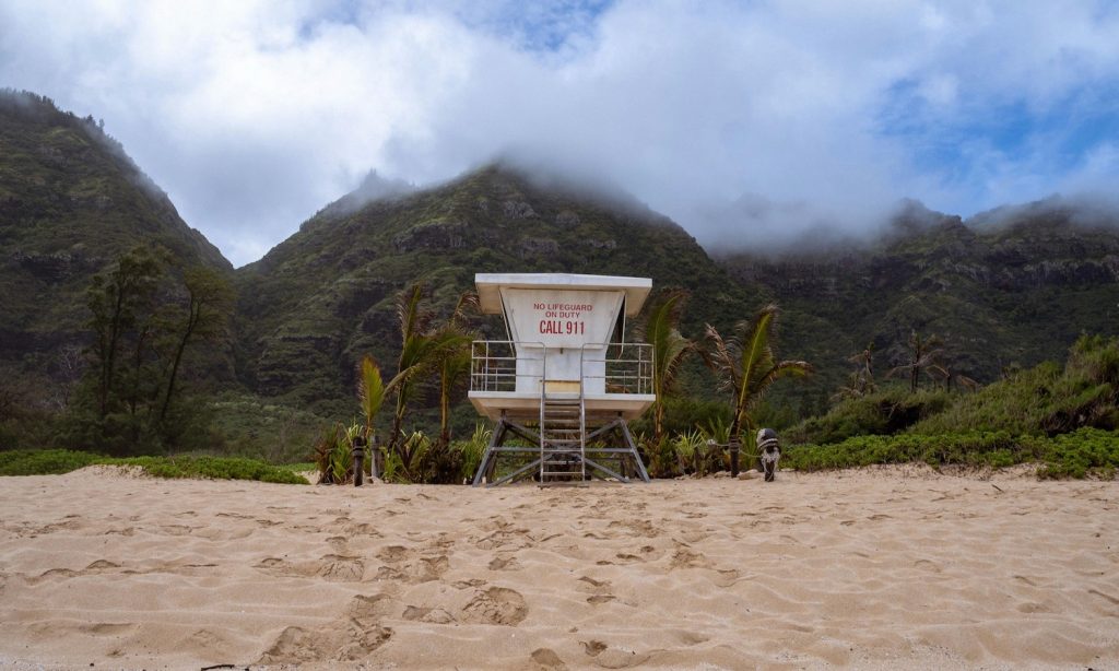 A lifeguard tower on the beach with a backdrop of mountains